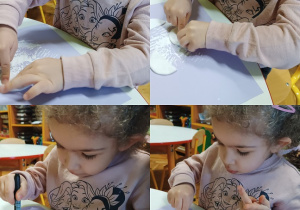 Dziewczynka siedzi przy stoliku i wykonuje pracę plastyczną "Niedźwiedź polarny".