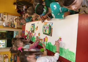 Dzieci malują na kartonie.