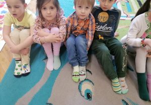 Dzieci pokazują dwie różne skarpetki.