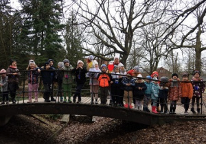 Dzieci stoją na mostku i pozują do zdjęcia.