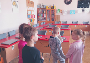 Dzieci zwiedzają salę komputerową.