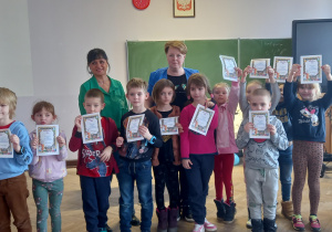 Zdjęcie grupowe dzieci pokazujących dyplom za udział w eksperymentowaniu.