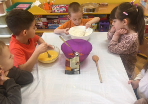 Dzieci mieszają składniki na ciasto marchewkowe.