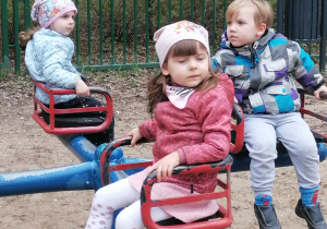 Dzieci siedzą na karuzeli.
