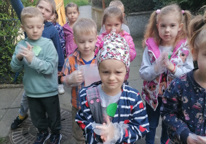 Dzieci zakładają jednorazowe rękawiczki.