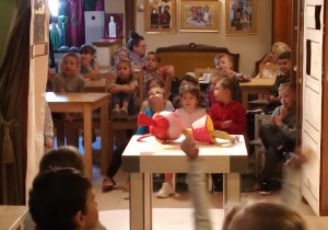 Zdjęcie dzieci siedzących przy stolikach.