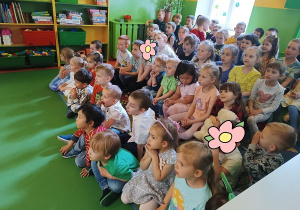 Zdjęcie dzieci siedzących i oglądających teatrzyk.