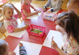 Dzieci rysują na kartonach.
