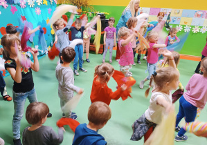 Zdjęcie dzieci tańczących z kolorowymi chustami.