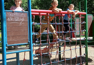 Zdjęcie dzieci stojących w domku i na mostku.