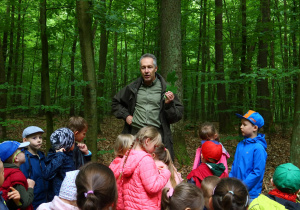 Zdjęcie przewodnika i dzieci w lesie.