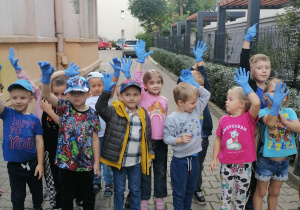 Dzieci pokazują niebieskie rękawiczki.