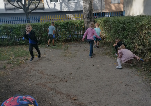 Dzieci poszukują śmieci na terenie ogrodu.