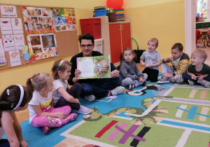 Mężczyzna pokazuje ilustrację.