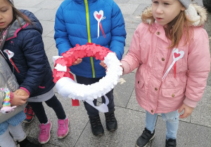 Dzieci trzymają wieniec.