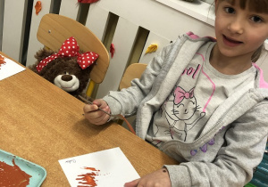 Dziewczynka maluje widelcem.
