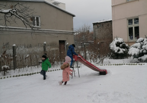 Dzieci biegają po śniegu.