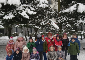 Dzieci z grupy niebieskiej pozują do zimowego zdjęcia.