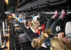 Dzieci zajmują swoje miejsca w teatrze.