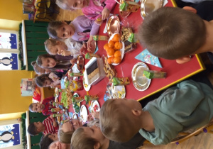 Dzieci siedzą za stołem.