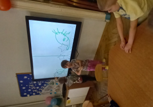 Dzieci rysują na ekranie interaktywnym dotykowym.