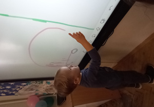 Dziecko rysuje na ekranie interaktywnym dotykowym.