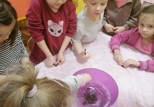 Dzieci kruszą czekoladę do miski.