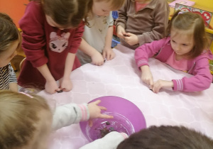 Dzieci kruszą czekoladę do miski.