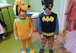 Dzieci przebrane za Pluto i Batmana pozują do zdjęcia.