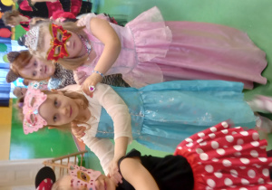 Dzieci robią wężyka. Na zdjęciu widać dziewczynki przebrane za Myszkę Mini i księżniczki.